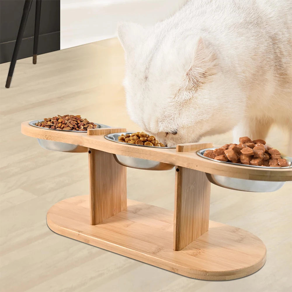 Râtelier à animaux en bois surélevé avec trois bols en acier inoxydable remplis de nourriture sèche.