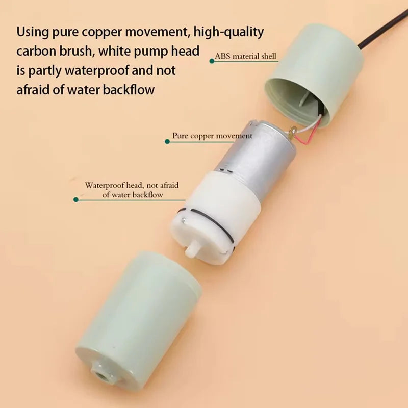 A close-up view of a white USB aquarium air pump with a copper brush and ABS material shell.