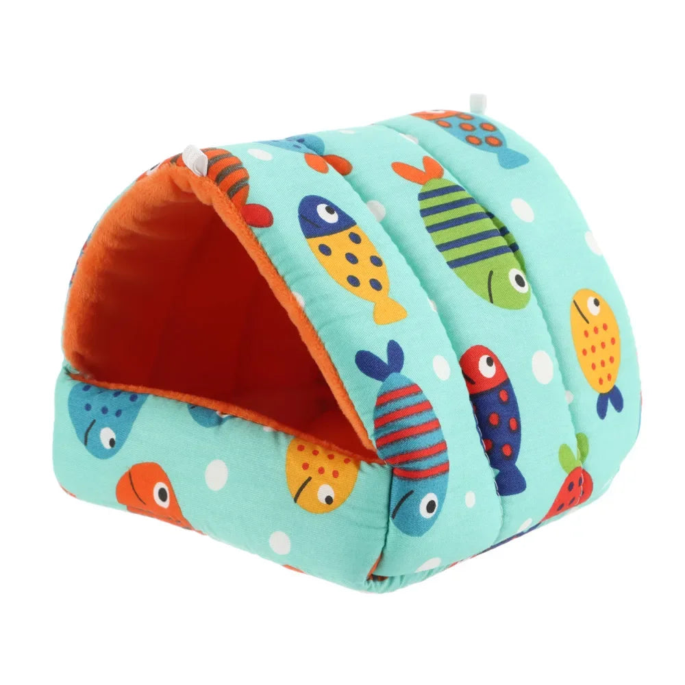 A teal flannel pet nest bed shaped like a fish, featuring colorful fish patterns and an orange lining.