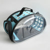 A transparent foldable pet travel carrier with a black shoulder strap and light blue accents.