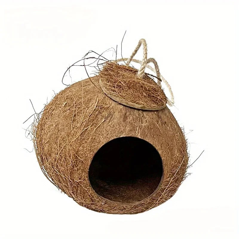 A natural coconut shell bird nest with straw fibers and twine, showing an entrance hole.
