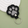 A black leather pet paw print charm with a gray paw pad and a silver keyring.