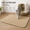 Eine tabby katze steht auf einem beigen, doppelten Katzenstreu-Matte vor einer weißen Katzentoilette.