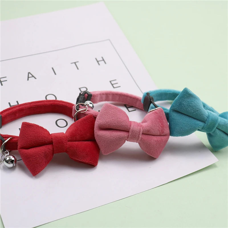 A set of plush velvet pet collars featuring bows in red, pink, and teal colors.