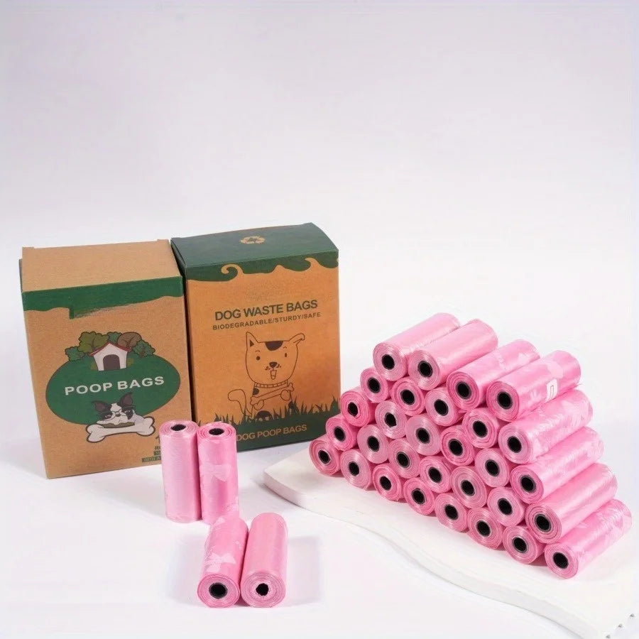 A pile of 20 pink puppy crown patterned dog waste bags is shown next to their cardboard packaging.
