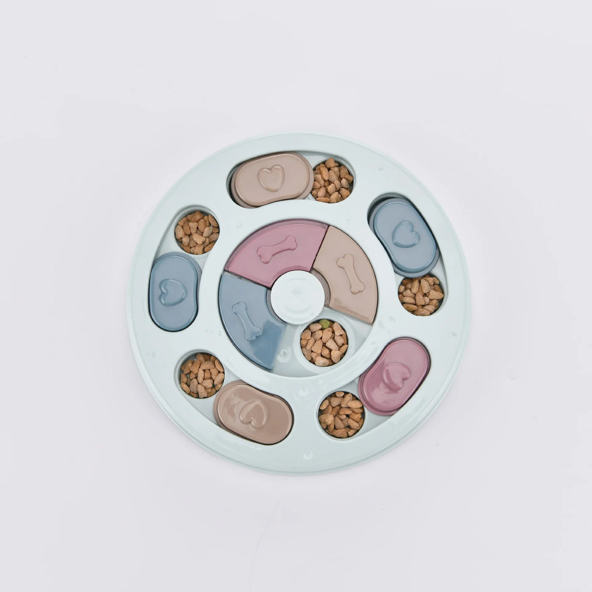 Jouet distributeur de nourriture circulaire pour animaux, avec des morceaux de nourriture ovales de différentes couleurs.