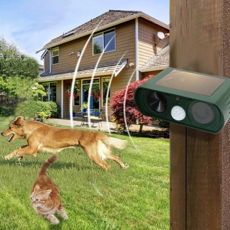 A solar-powered ultrasonic animal repeller device is mounted on a wooden post, with a dog and a cat visible in the green lawn