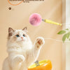 A fluffy white cat is playing with an electric interactive cat teaser toy wand.
