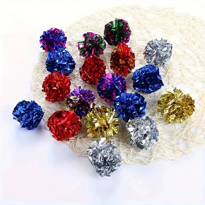 A collection of colorful crinkle cat balls in various shades including purple, red, blue, and silver, displayed on a white me