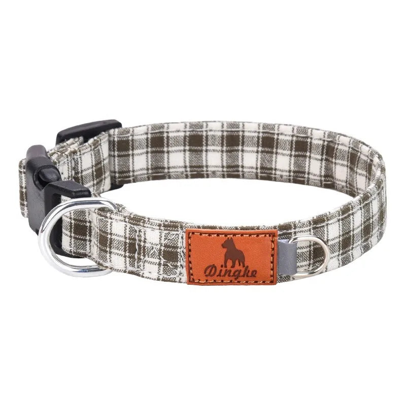 A plaid polyester dog collar with a leather patch and buckle is shown against a white background.