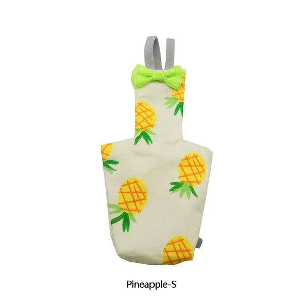 A light yellow fabric item shaped like a pineapple with green leaves and a lime green bow.