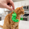 Eine orange tabby Katze wird einem grün gedruckten Muskelkostüm für Haustiere gezeigt.