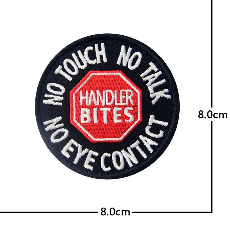 Black embroidered patch with red text and a hexagonal logo on the front, featuring phrases like NO TOUCH NO TALK and HANDLER 