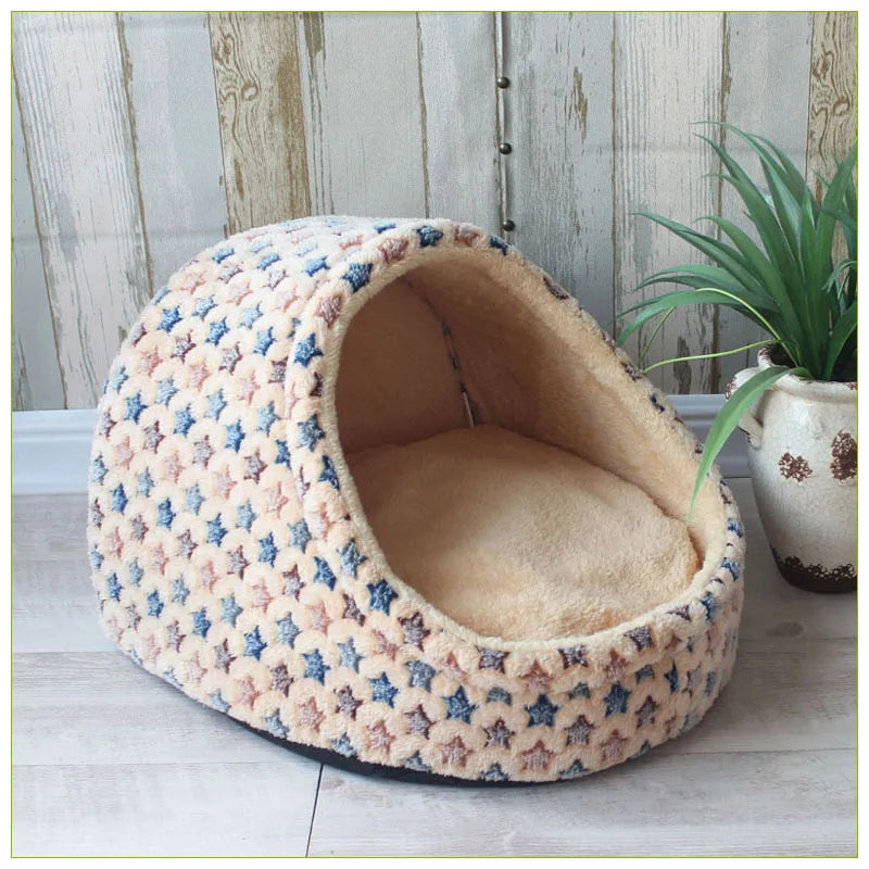 A round, beige and blue patterned pet bed shaped like a cave for small and medium dogs.