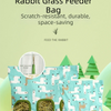A teal fabric bag filled with hay, featuring a pattern of white rabbits and woodland scenery.