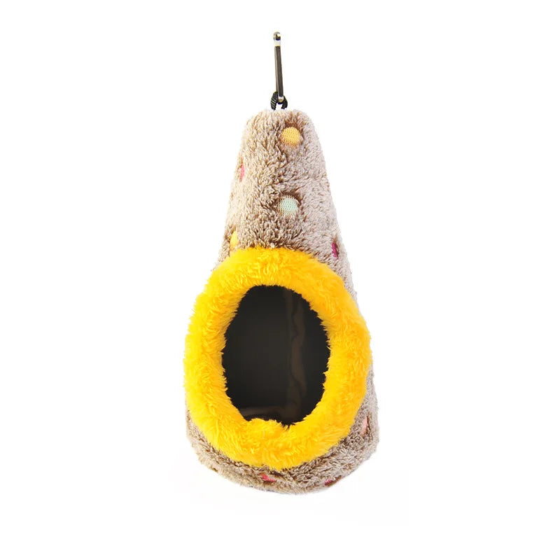 A fluffy, light brown bird nest with a yellow entrance, hanging from a metal hook.