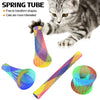 A kitten plays with a colorful spring toy set, showing various shapes and colors of the bouncy springs.