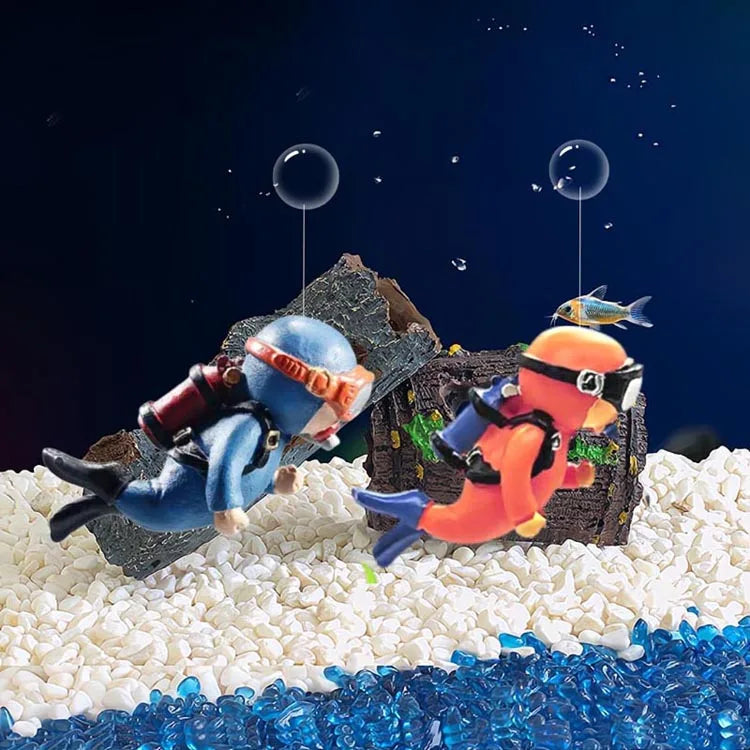 Miniature diver aquarium decoration featuring a diver and a floating ball on a white surface.