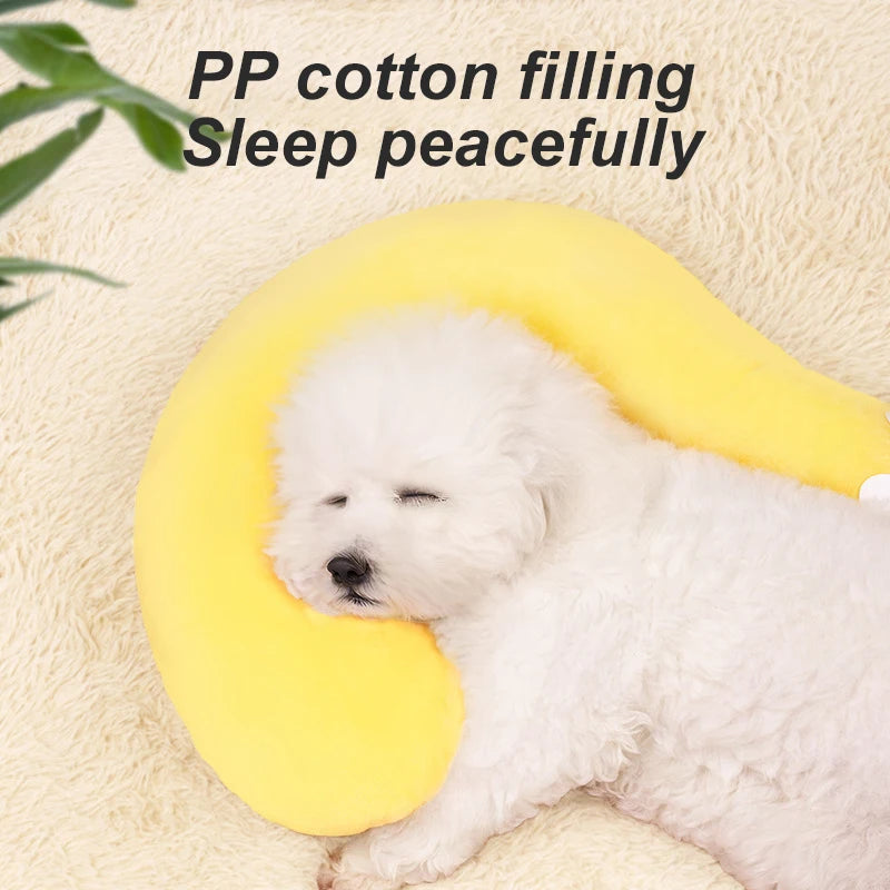 Un perro blanco está descansando sobre una almohada de cuello para mascotas en forma de U, hecha de relleno de algodón PP.