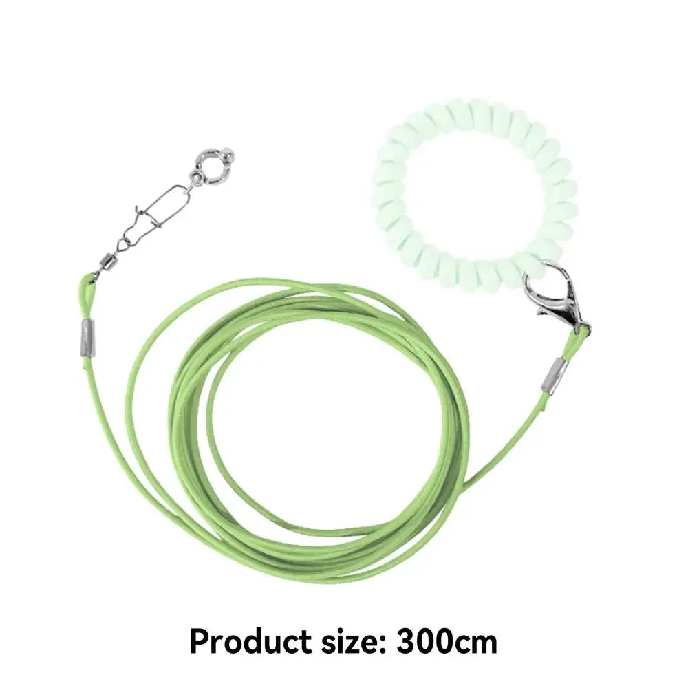 A green parrot flight training leash with a white foot ring and a coiled green cord.