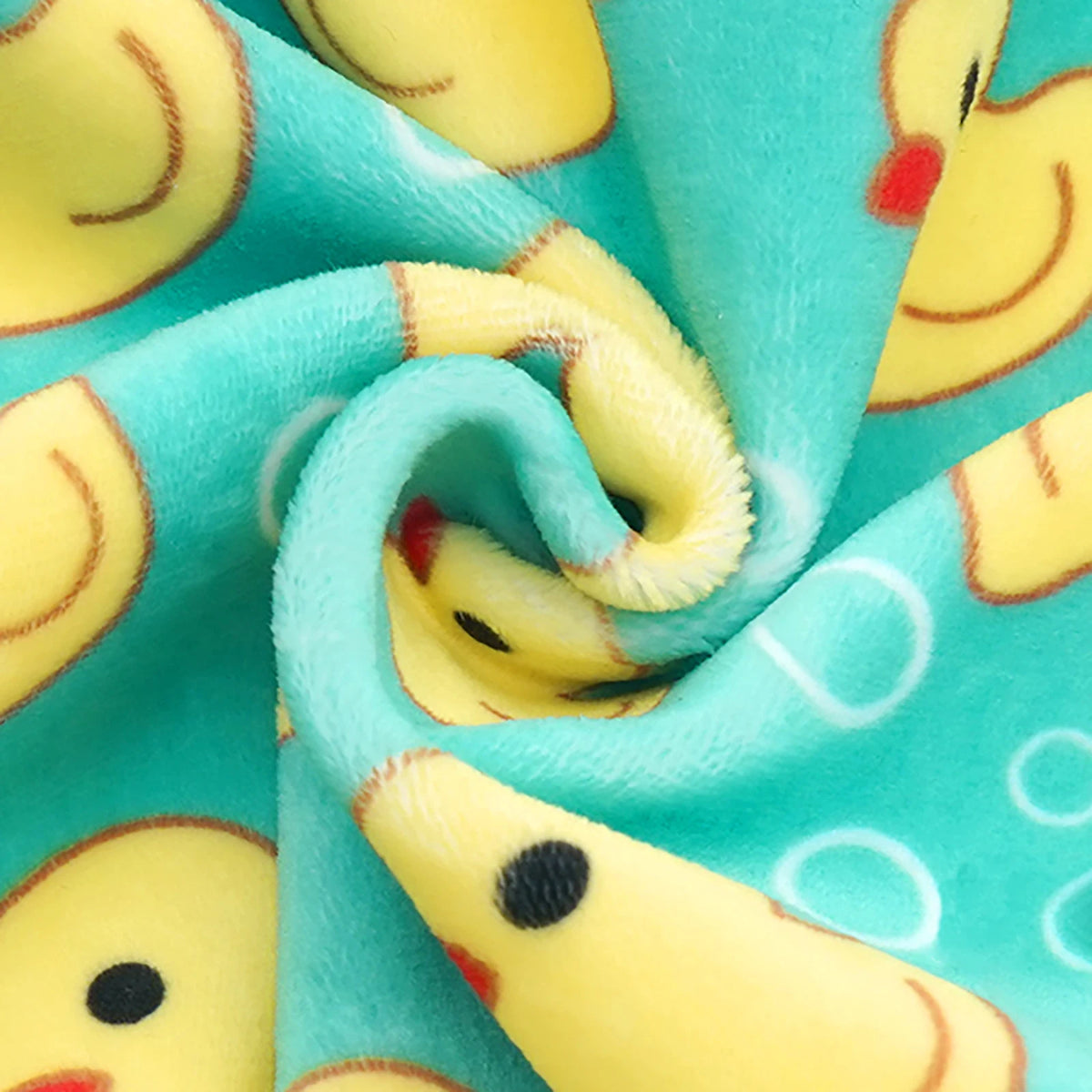 Fabric pattern featuring yellow duck faces on a teal background