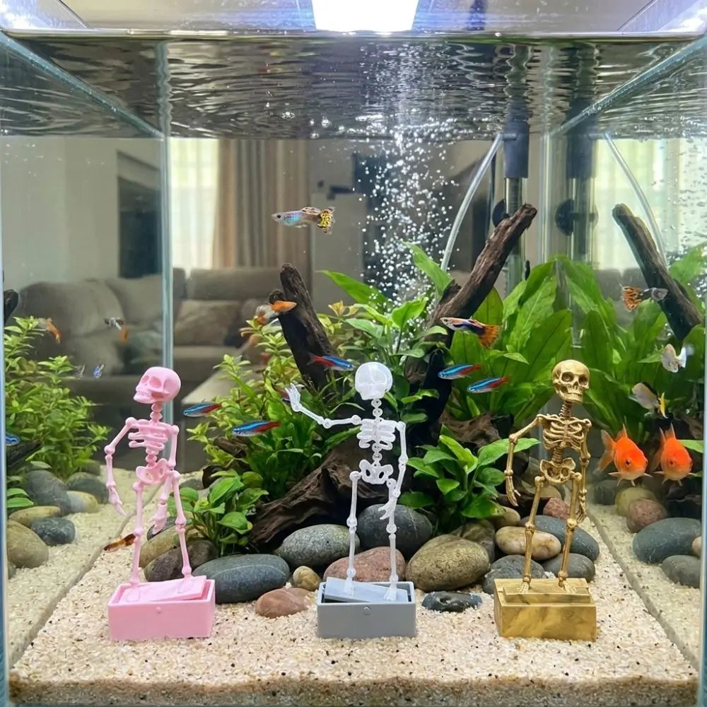 A display of a dancing skeleton figure and various aquatic decorations inside a glass aquarium.