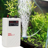 A white portable battery air pump is shown operating water spray in a small aquarium or planted area.