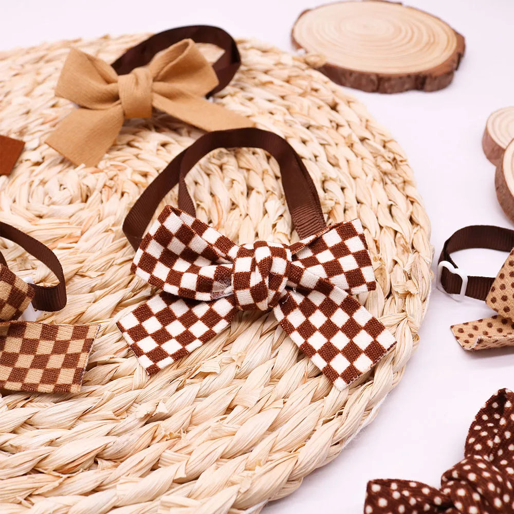 A brown plaid and brown dot pet bow tie for dogs and cats displayed on a woven mat.