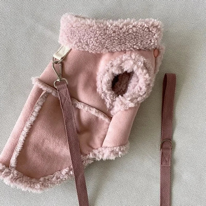 A pink luxury cotton dog vest with fluffy trim and a pink strap is shown on a light background.
