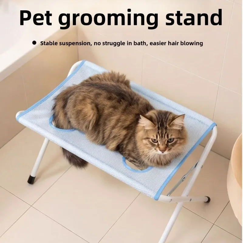 A fluffy tabby cat is resting on a blue mesh grooming stand for pet bathing.
