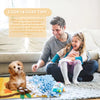 A man and a girl are playing with a dog on a blanket, demonstrating pet sniffing training.