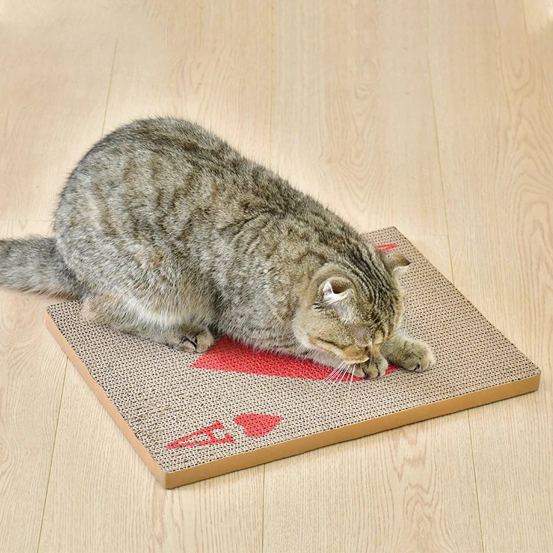 A tabby cat is resting on a beige vertical cat scratcher mat with a red marker mark.