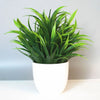 A vibrant green artificial bonsai plant in a white pot, displayed indoors.
