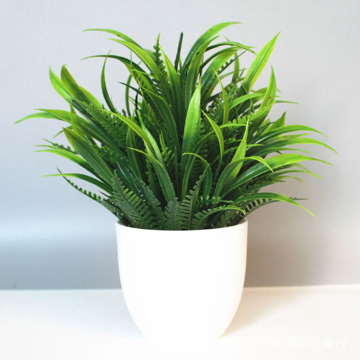 A vibrant green artificial bonsai plant in a white pot, displayed indoors.