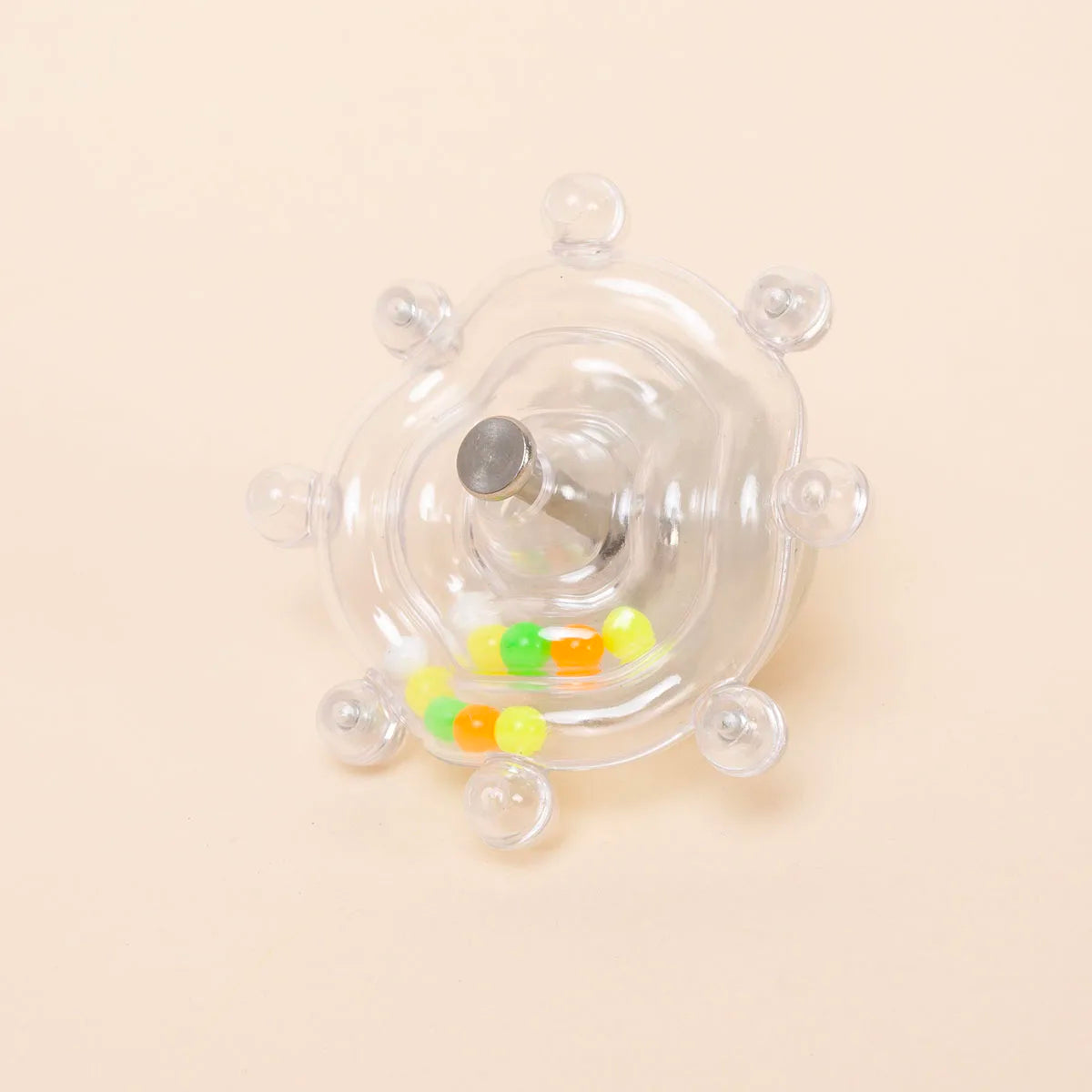 Interaktiver rotierender Futterspender für Papageien mit klarem Plastikgehäuse und bunten Leckereien.