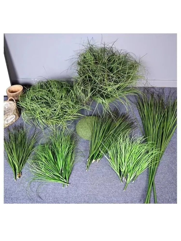 A collection of green simulated onion grass used as garden decoration, displayed on a gray surface.