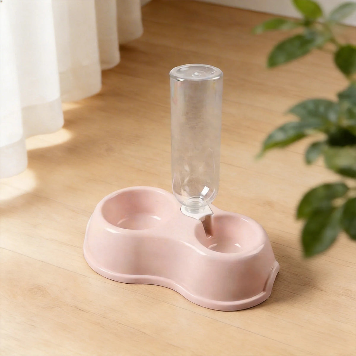 A pink dual-bowl feeder for cats and dogs with a clear water dispenser sitting on a wooden surface.