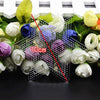 A set of precision hama beads tweezers with various colored beads and green leaves.