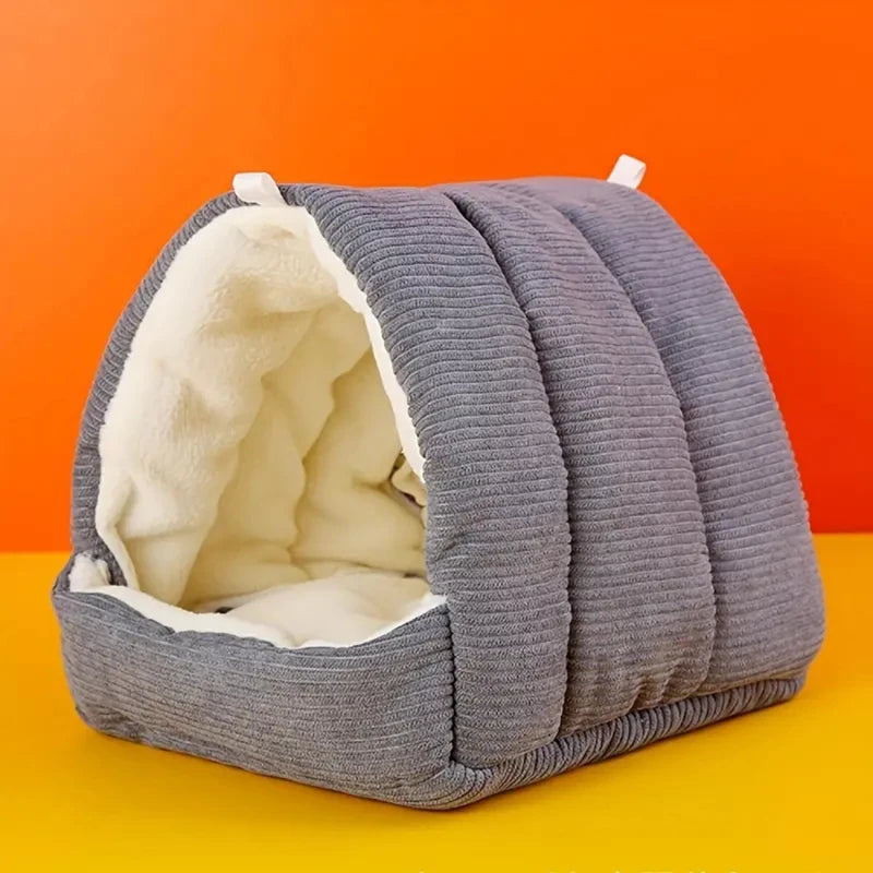 A gray quilted cozy cotton bird nest with a white interior, displayed on an orange background.