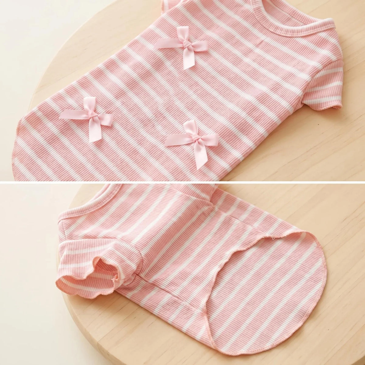 A pink and white striped knit pet shirt with a bow detail shown flat lay.
