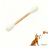 Una espátula de madera con forma de gato junto a un gatito naranja.