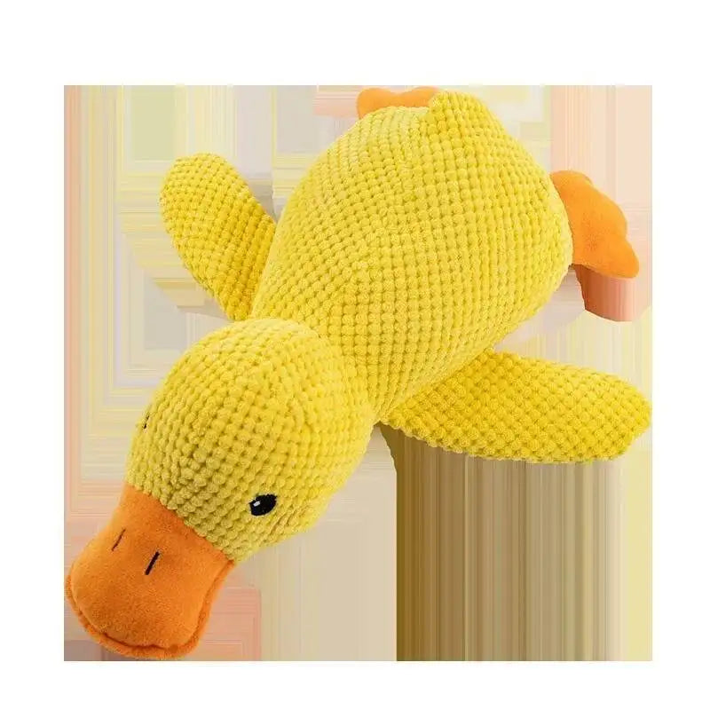 A yellow plush duck toy with orange feet and beak, designed as a calming dog toy.