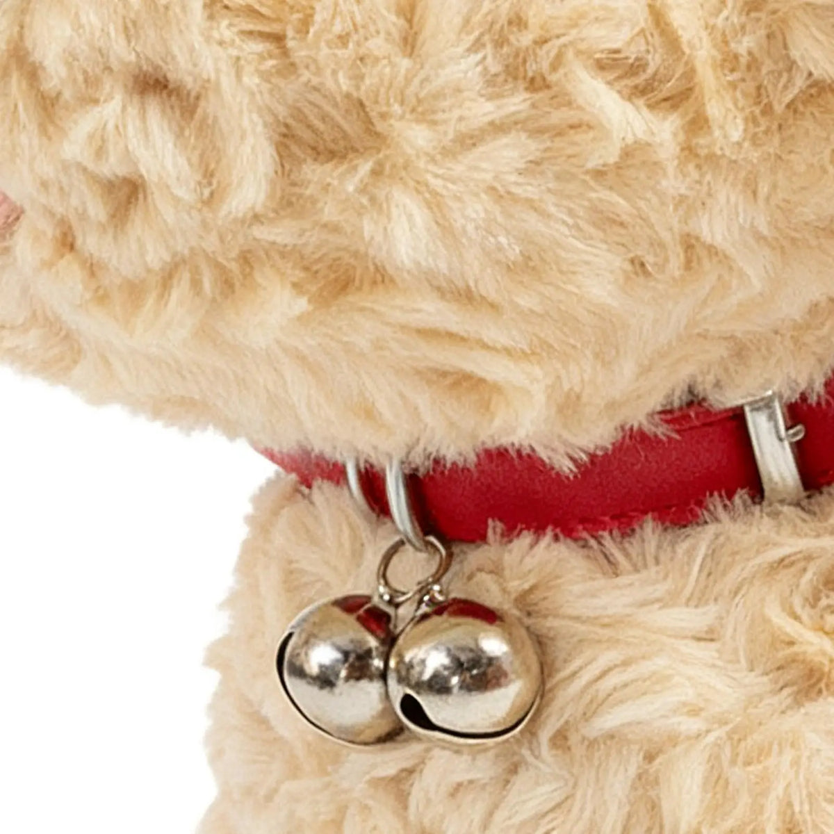 Nahaufnahme eines braunen Plüschpuppy mit rotem Halsband und silbernem Klingendekor