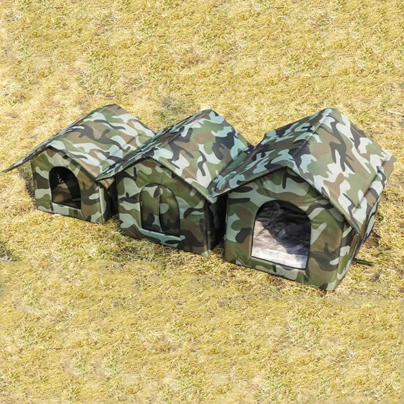 Trois maisons de chat outdoor camouflage construites dans un champ herbeux.