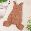 A tan dog denim jumpsuit costume for small to medium breeds lying on a light wooden surface.