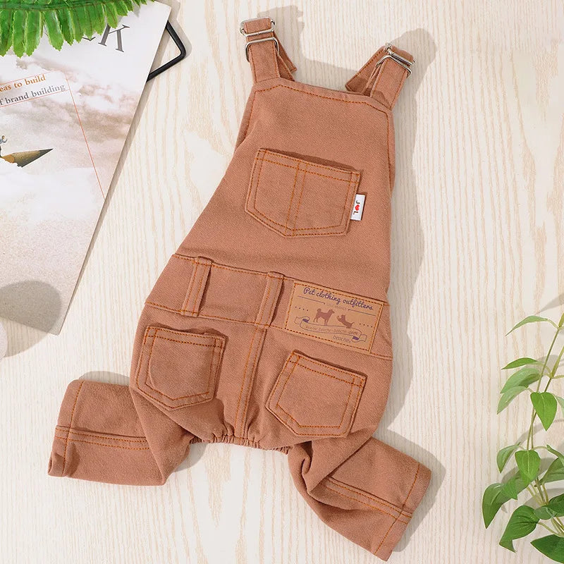 A tan dog denim jumpsuit costume for small to medium breeds lying on a light wooden surface.