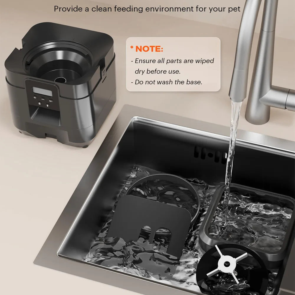 A black automatic pet feeder is shown dispensing food into a stainless steel tray.