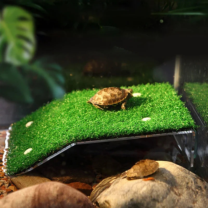 A turtle basking platform featuring a green grass ramp and suction cups on a dark background.