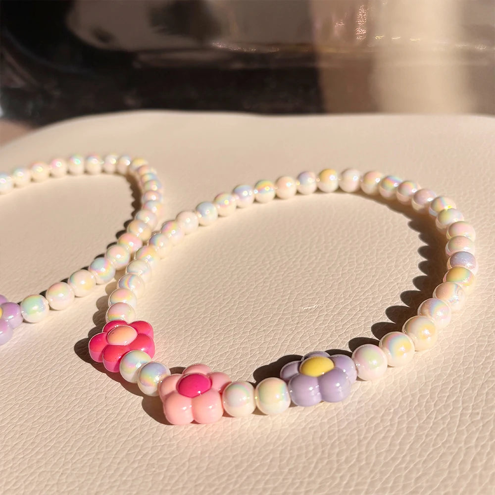 A set of pastel floral beaded necklaces featuring pink, purple, and white beads.