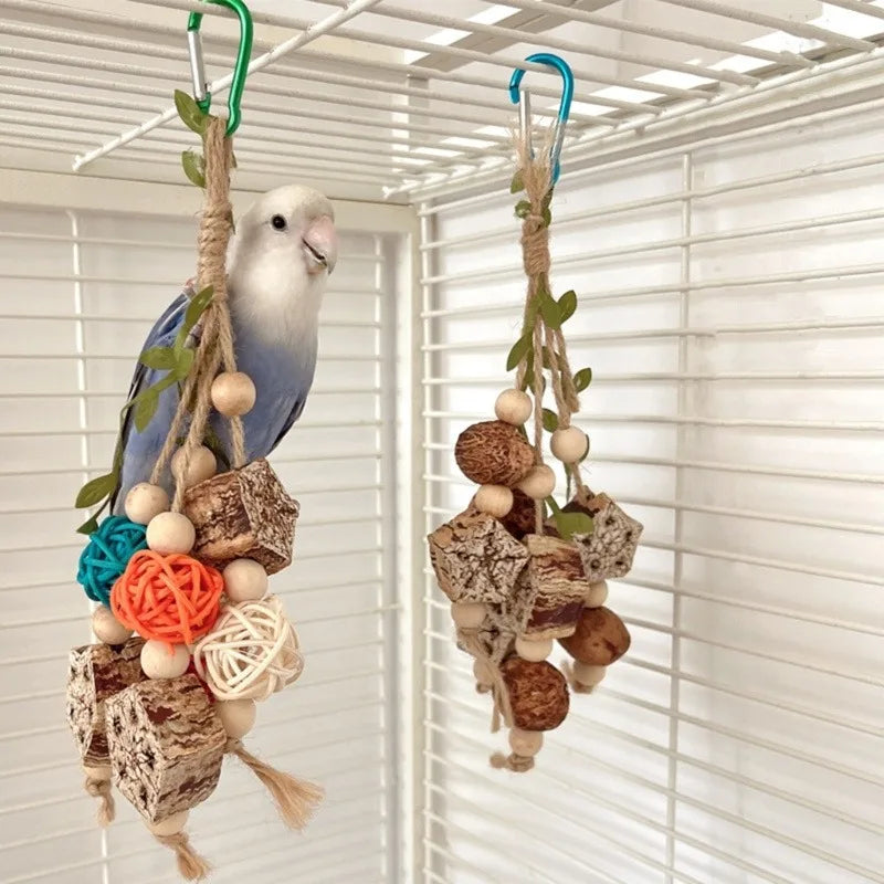 A white parrot is hanging from a natural fiber toy decorated with wooden and fabric accents.
